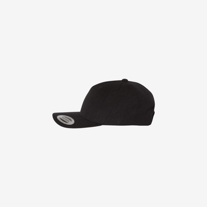 Side view of Black YP Classics 5789M premium five-panel snapback cap showing the structured mid-profile crown and curved bill